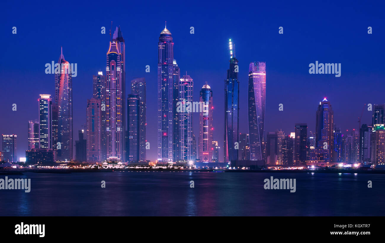 Weiten Blick auf die Skyline von Dubai an der Küste während der Blauen Stunde, mit modernen Gebäuden und Wolkenkratzern bis lit. Februar 2016. Stockfoto