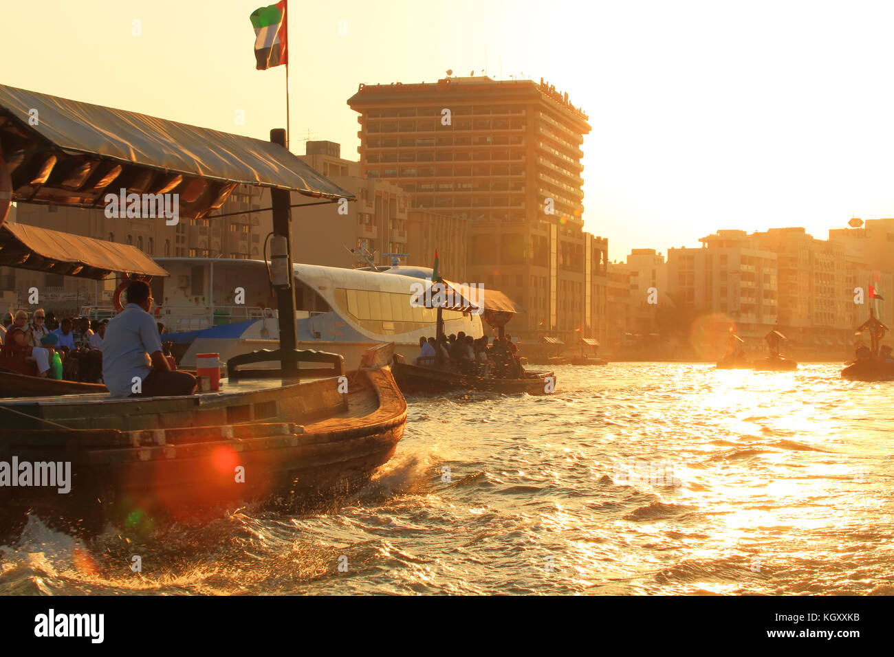 Das historische Zentrum von Dubai am Abend. Holz- Touristische boote in der Bucht von Dubai am Sonnenuntergang. Boote zum Alten Markt in Dubai. Stockfoto