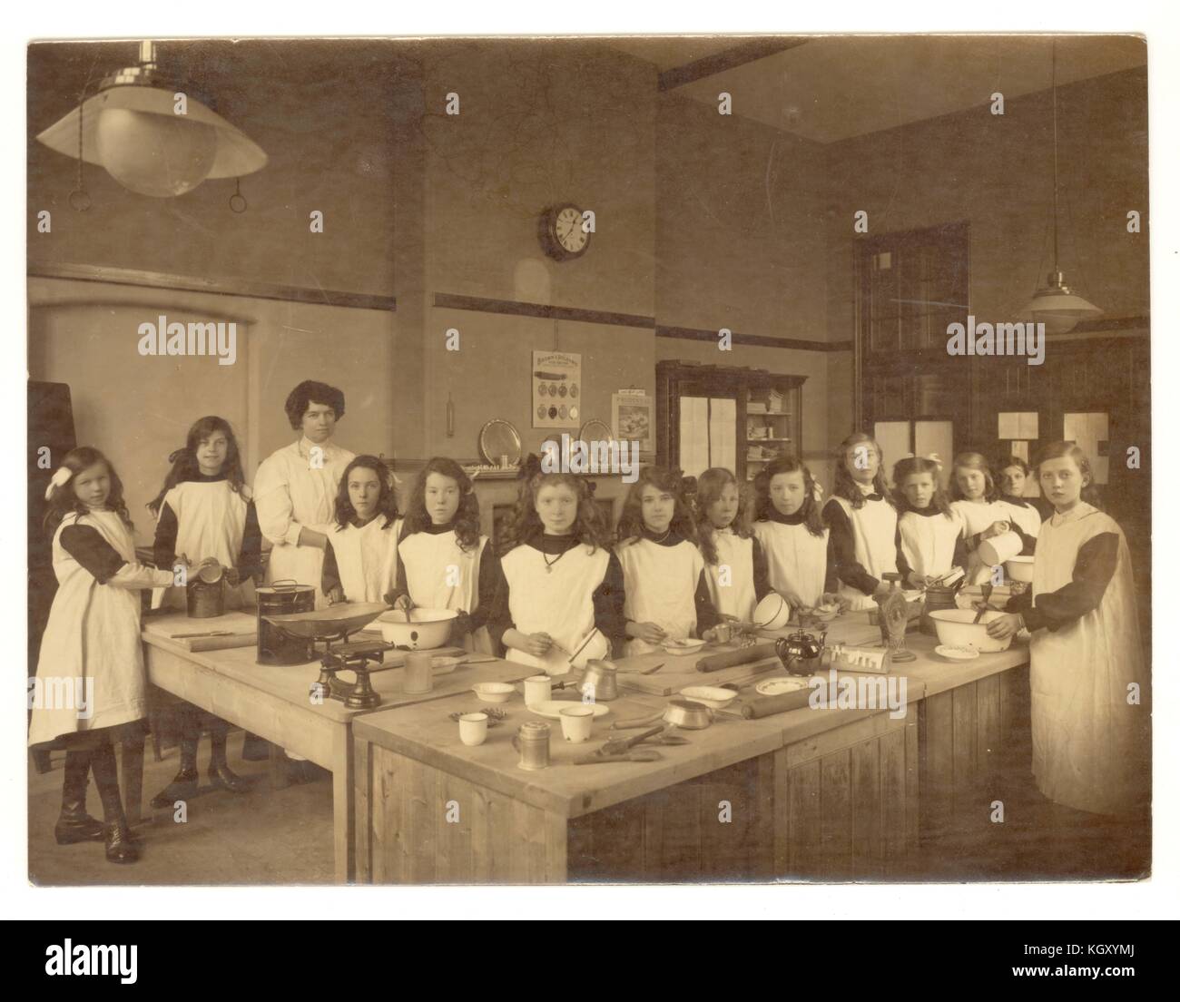 Originalfoto des Edwardianischen Mädchen in einem Hauswirtschaft Klasse, lernen Backen und Kochen in der Küche, um 1910, Großbritannien Stockfoto