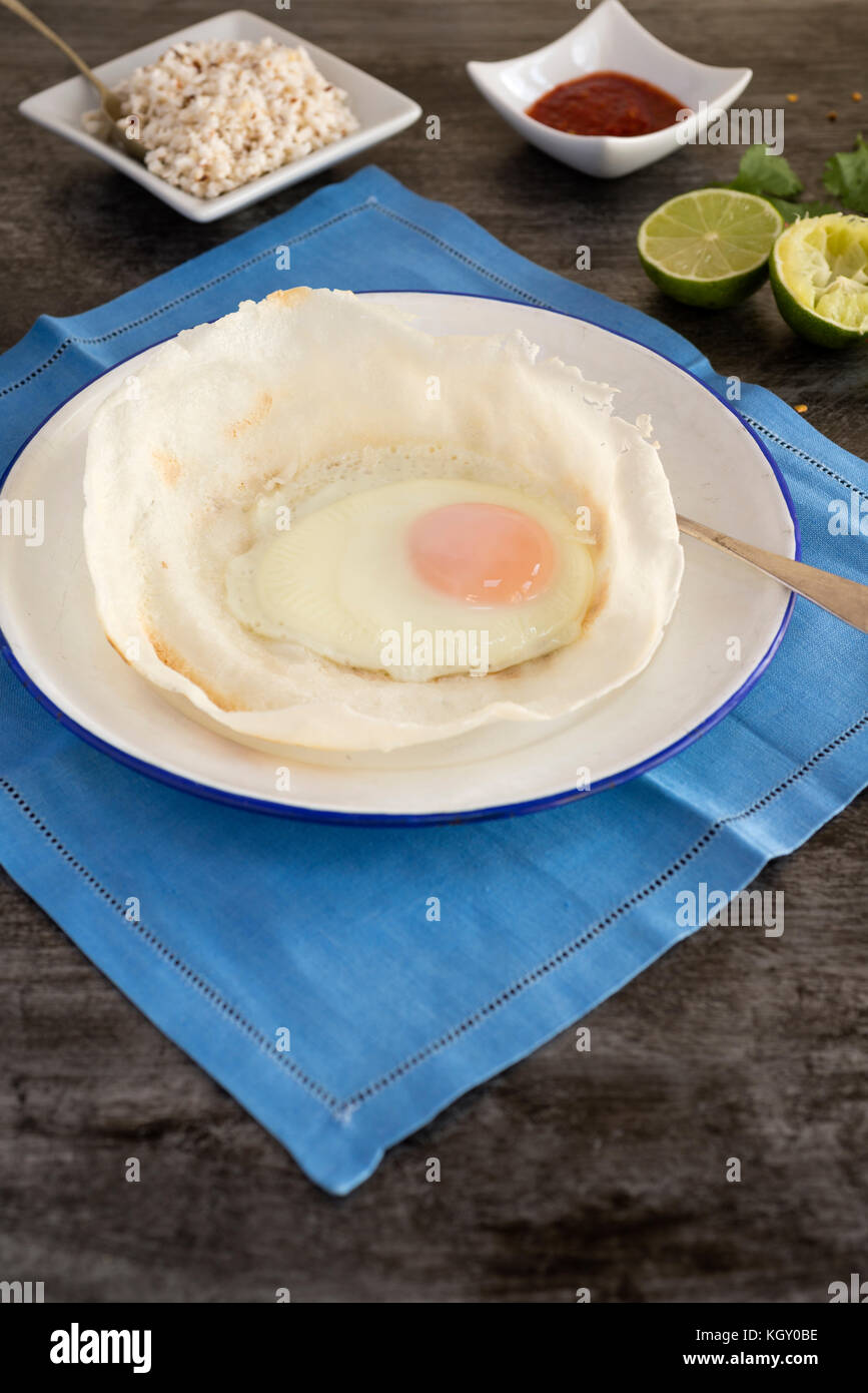 Sri Lankan Trichter mit Ei, serviert mit Kokosnuss sambol und Chili. Stockfoto