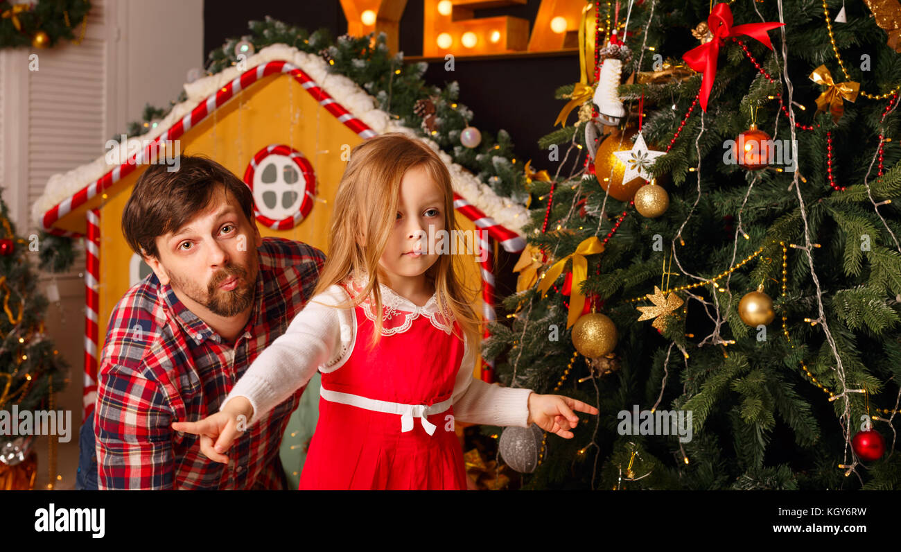 Weihnachten mit der Familie. Vater und Tochter um täuschen am Weihnachtsbaum. Vorbereitung für einen Familienurlaub. Stockfoto