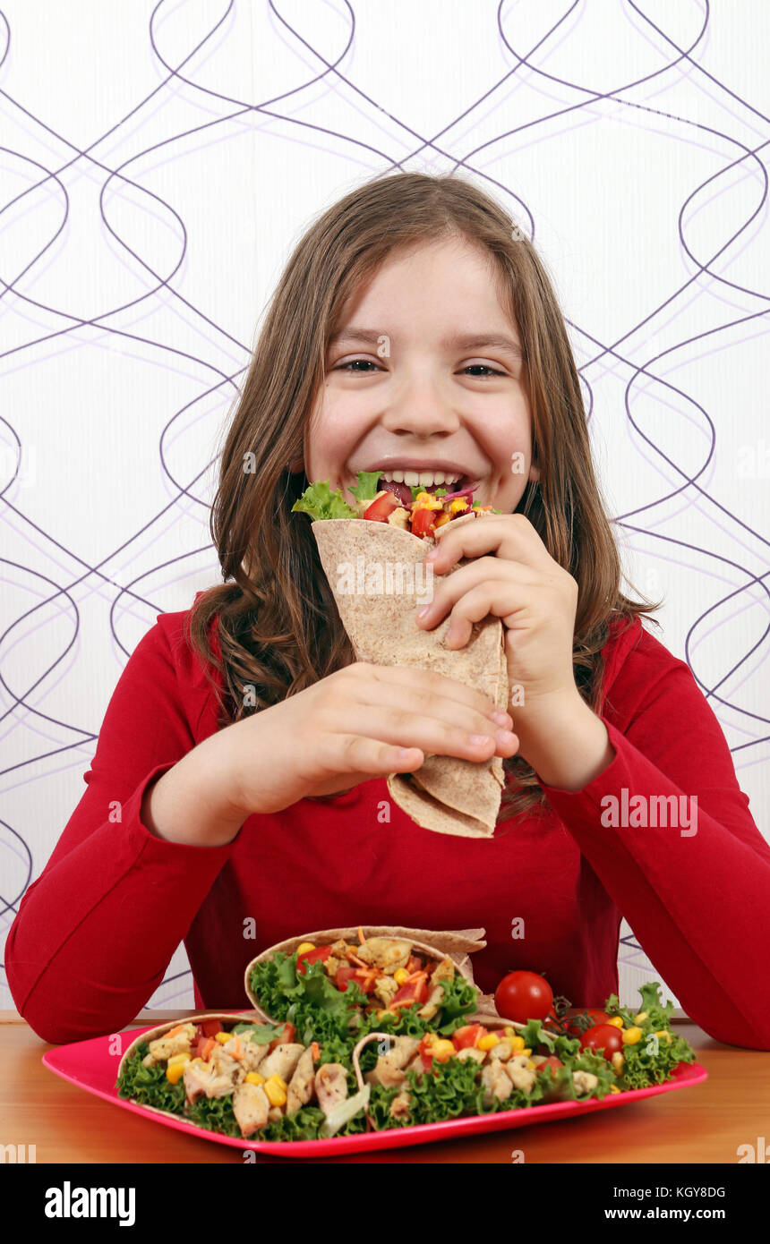 Hungrige kleine Mädchen essen burritos Stockfoto
