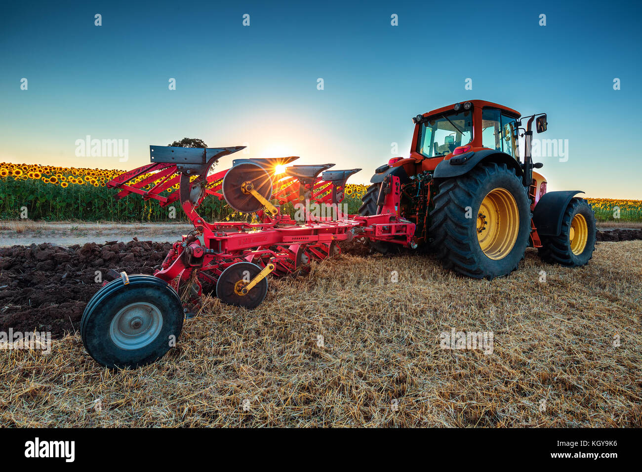 Bauer im Traktor Vorbereitung land mit grubber Stockfoto