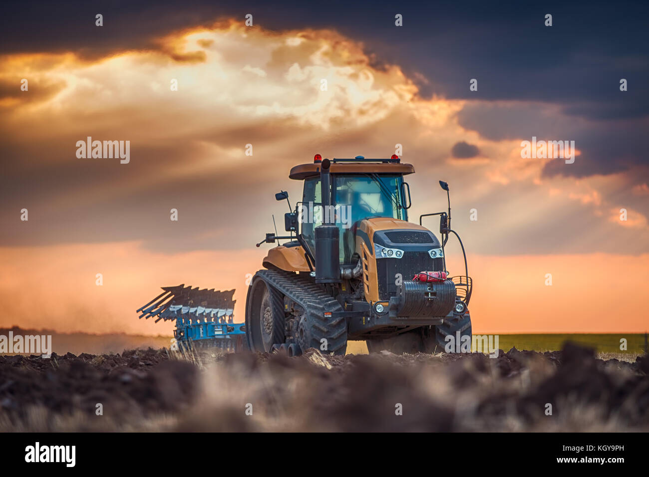 Bauer im Traktor Vorbereitung land mit grubber Stockfoto