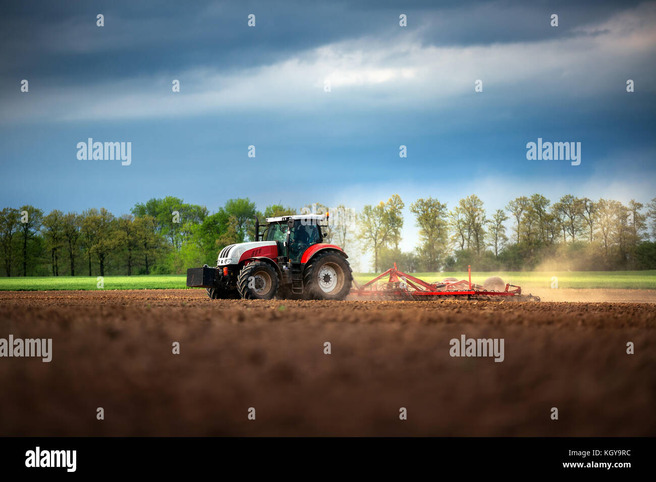 Landwirt in Vorbereitung der Flächen mit Saatbeet Grubber Traktor Stockfoto