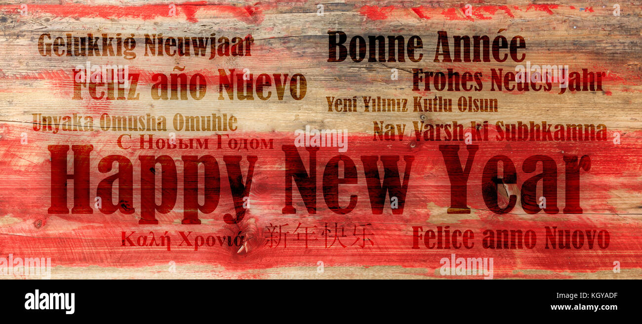 Ein frohes neues Jahr wünschen in vielen Sprachen auf rotem Holz- Hintergrund Stockfoto