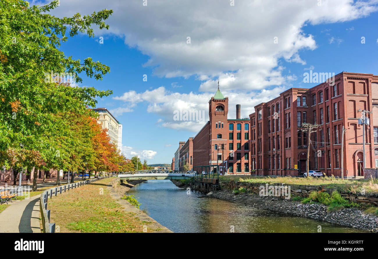 Blick auf ein Mühlengebäude mit blühenden Bäumen entlang der Canal Street in Lawrence, Massachusetts. Stockfoto