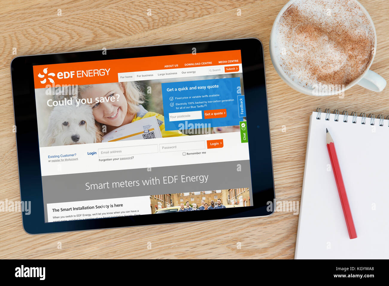 Die EDF Energy website Funktionen auf einem iPad Tablet Device, die auf einer hölzernen Tisch neben einem Notizblock und Bleistift und eine Tasse Kaffee beruht (nur redaktionell) Stockfoto