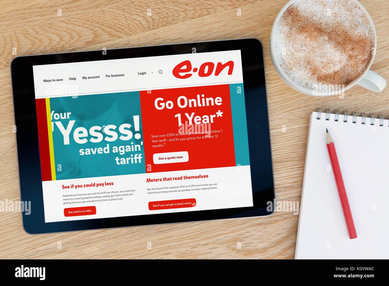 Die E.ON-Website auf einem iPad Tablet Gerät, das auf einem Tisch liegt neben einem Notizblock und Bleistift und eine Tasse Kaffee (nur redaktionell) Stockfoto