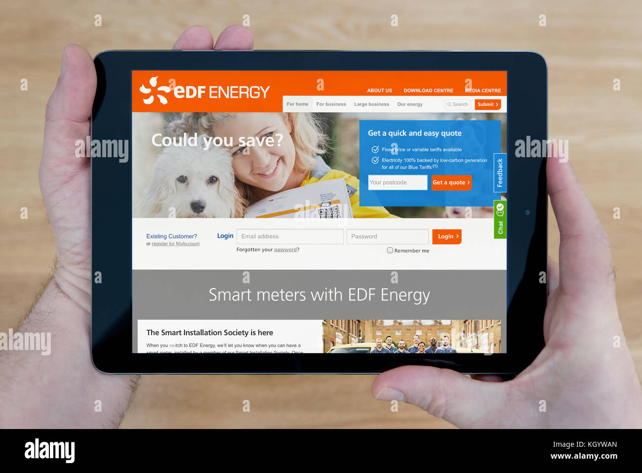 Ein Mann schaut auf die EDF Energy Website auf seinem iPad tablet device, Schuß gegen einen hölzernen Tisch top Hintergrund (nur redaktionelle Nutzung) Stockfoto