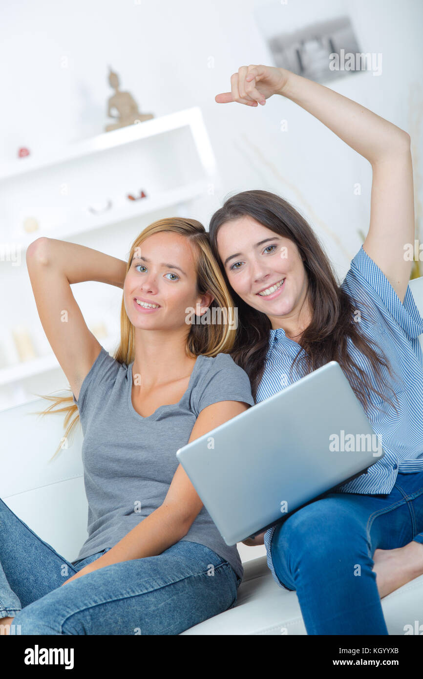 Lächelnde Frauen suchen finanzielle Dokumente mit Laptop im Home Stockfoto