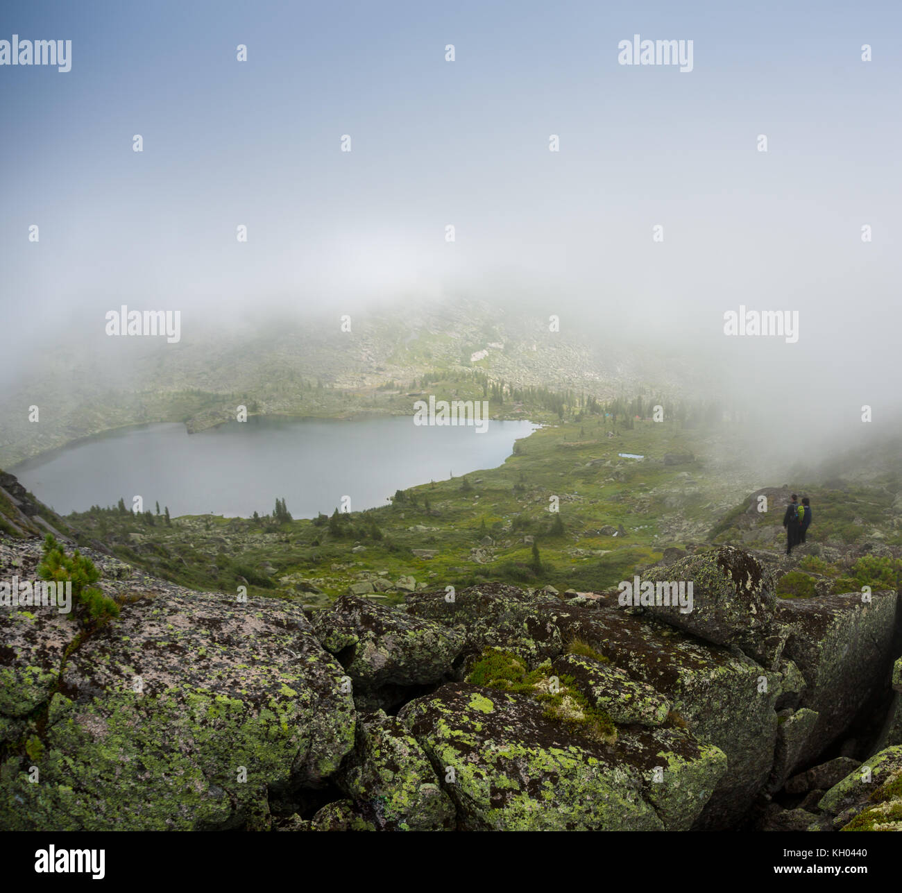 Paare im Nebel auf der Seebrücke am Winternachmittag. Friedliche Atmosphäre. Nebelluft. Stockfoto
