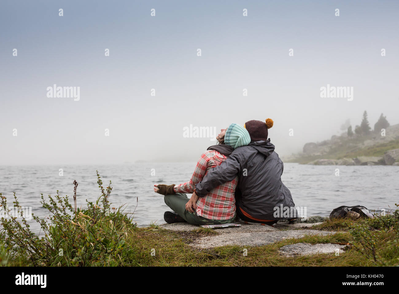 Paare im Nebel auf der Seebrücke am Winternachmittag. Friedliche Atmosphäre. Nebelluft. Stockfoto