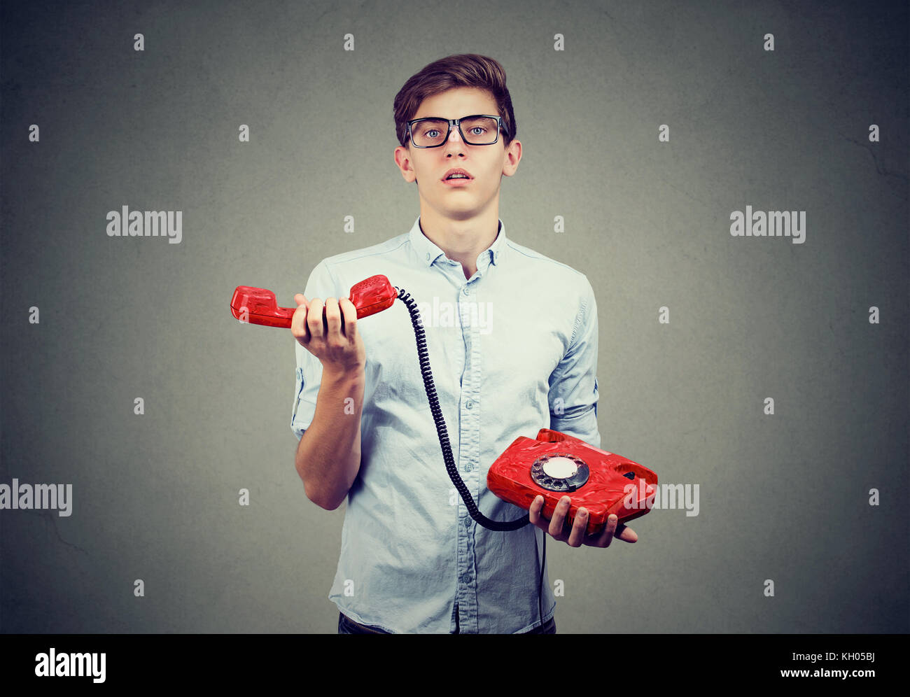 Verwirrt teenager Mann mit altmodischen Telefon Stockfoto