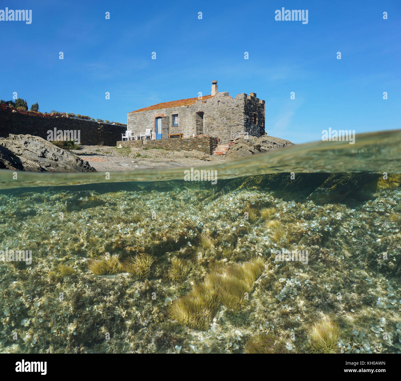 Über und unter Wasser Oberfläche, alte steinerne Haus am Meer mit Seeanemonen und Algen, Unterwasser, Mittelmeer, Cadaques, Costa Brava, Spanien Stockfoto
