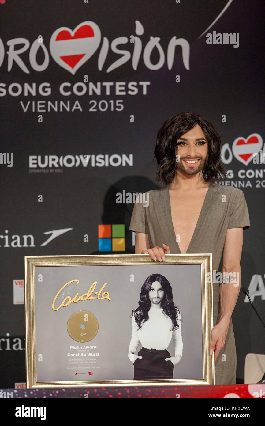 Ein Sony Record-Vertreter überraschte Conchita Wurst mit einem „Platinum Award“ für 15,000 verkaufte Schallplatten in Österreich bei der Conchita Wurst Pressekonferenz beim Eurovision Song Contest 2015 in Wien (Gonzales Photo/Michael Hornbogen). Stockfoto