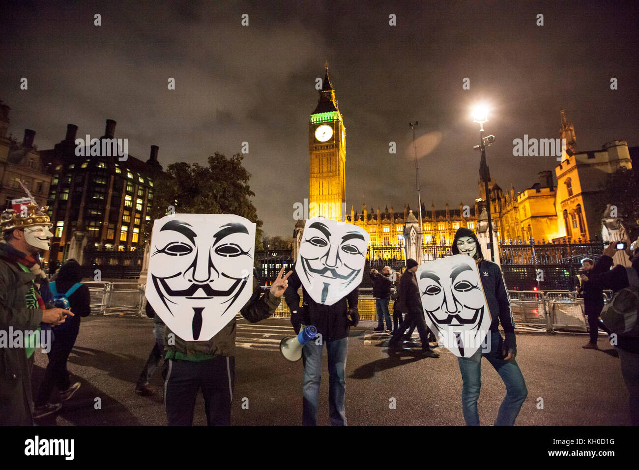 Demonstranten mit Guy Fawkes Masken Kundgebung durch London bei der Million Mask März 2015. Hier Big Ben und das Parlament im Hintergrund. Stockfoto