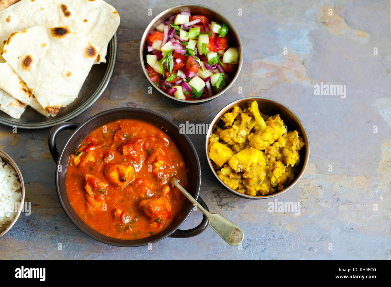 Indisches essen mit Chicken Tikka Masala, Aloo Gobi, Salat, Reis und Brot Stockfoto