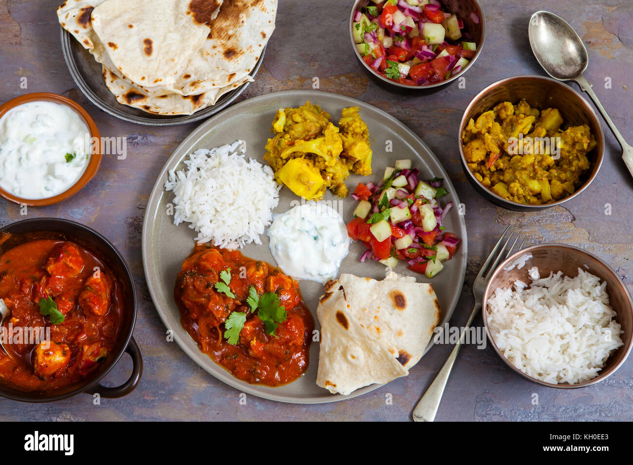Indisches essen mit Chicken Tikka Masala, Aloo Gobi, Salat, Reis und Brot Stockfoto