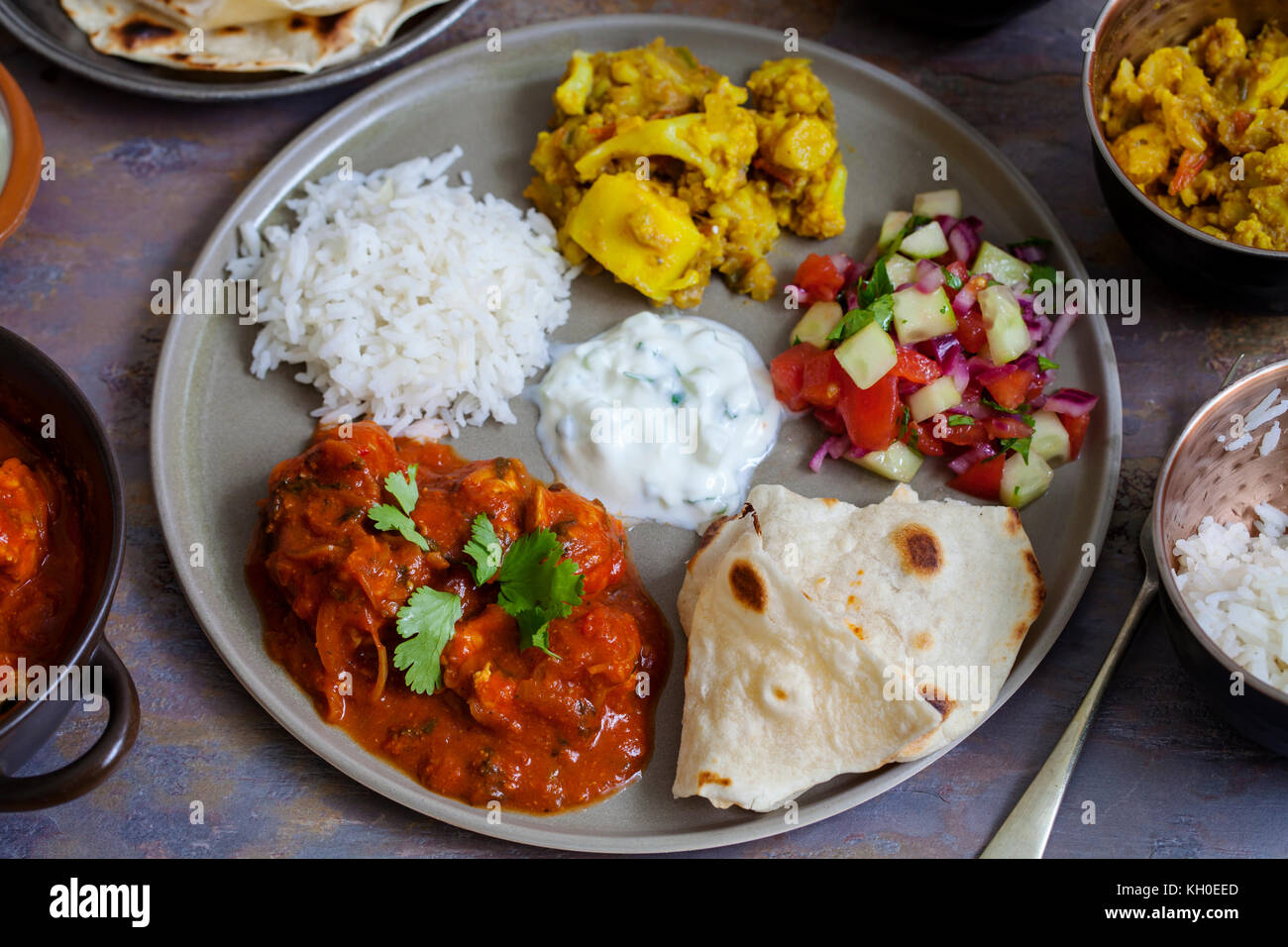 Indisches essen mit Chicken Tikka Masala, Aloo Gobi, Salat, Reis und Brot Stockfoto