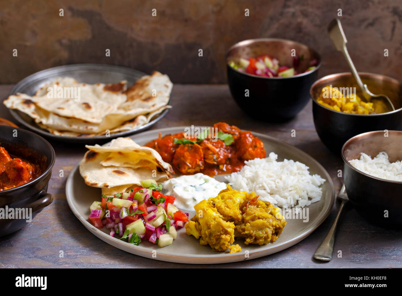 Indisches essen mit Chicken Tikka Masala, Aloo Gobi, Salat, Reis und Brot Stockfoto