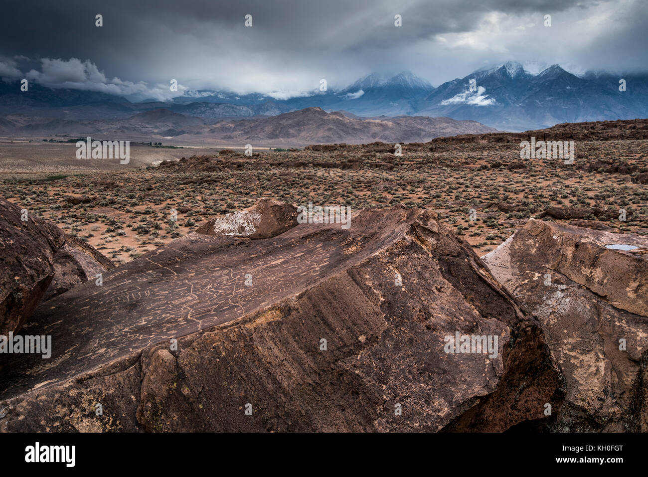 Sky Rock, einen Blick gen Himmel Serie von petroglyphen von der Paiute-Shoshone Inder vor Tausenden von Jahren links, sitzt, bevor die Berge der Sierra Nevada. Stockfoto