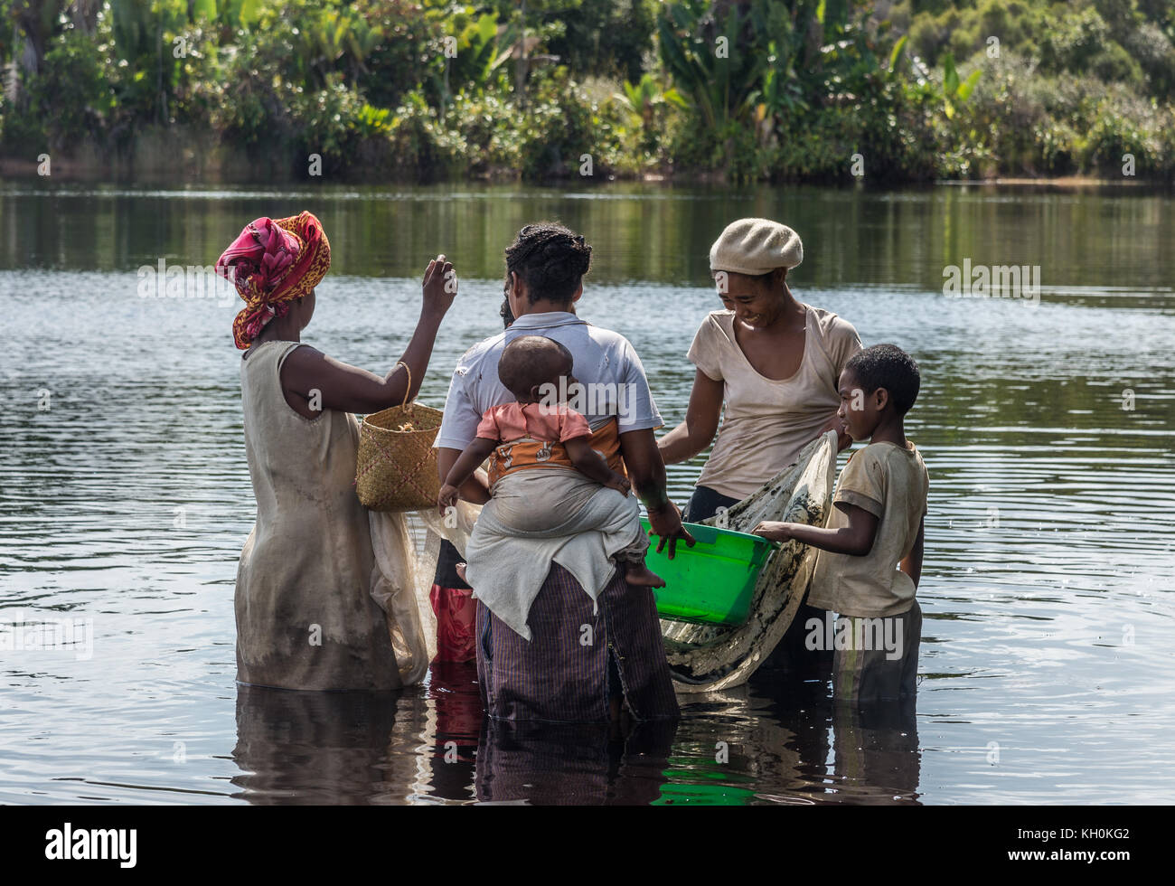 Mehrere madagassische Frauen mit Kindern fangen Fische in einem See. Madagaskar, Afrika. Stockfoto