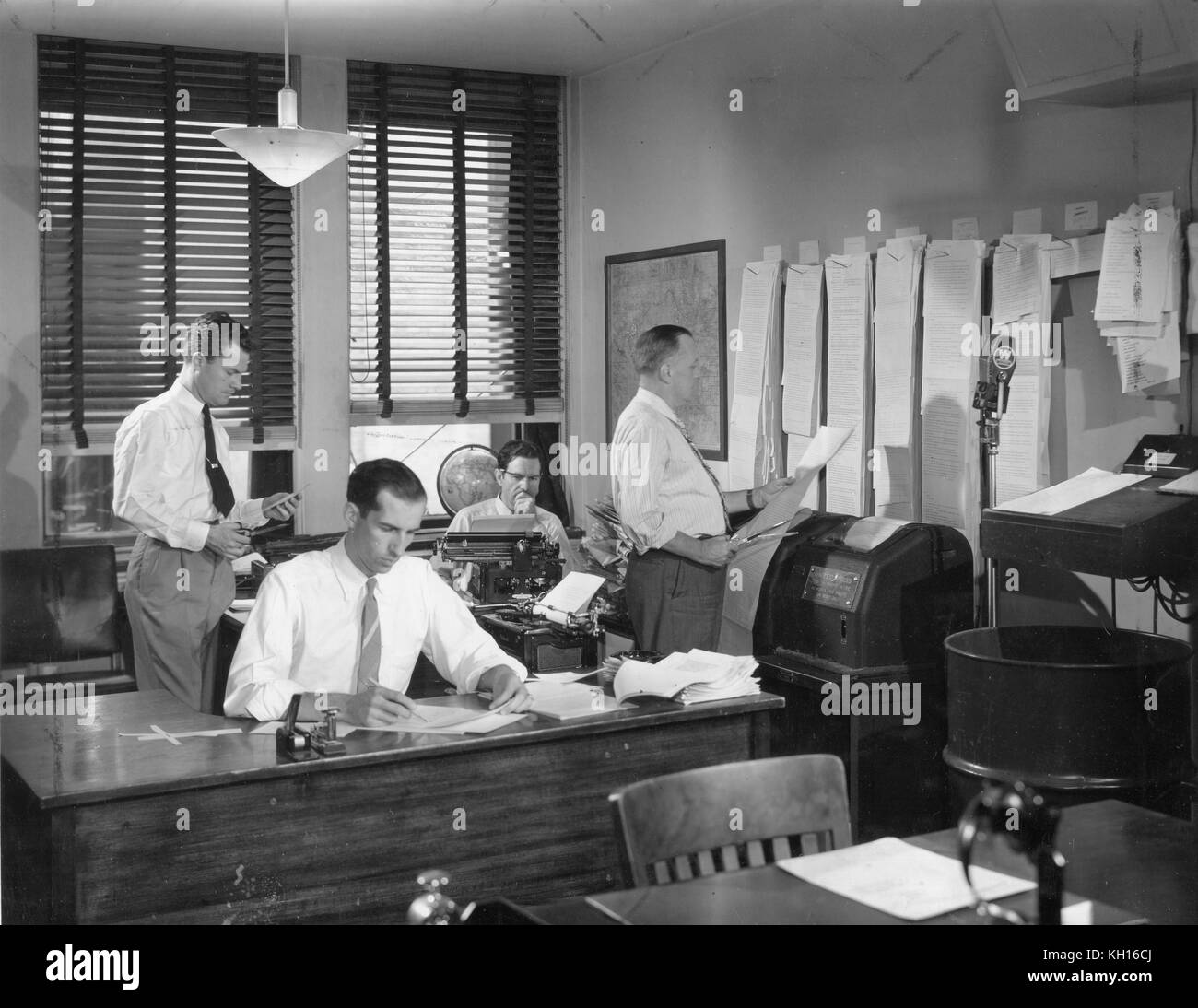 Der Newsroom in einer großen US-Radiosender sammelt Nachrichten über Fernschreiber aus allen Teilen der Welt an, die sortiert, bearbeitet und an die Zuhörer ausgestrahlt werden, New York, NY, 1949. Stockfoto