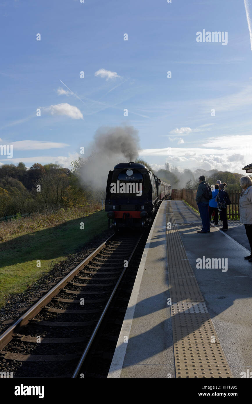 Dampfzug an Plattform ankommen, Passagiere warten hinter haptische Oberfläche, lange Schatten, um Grate Country Park Bahnhof Lancashire England bury Stockfoto