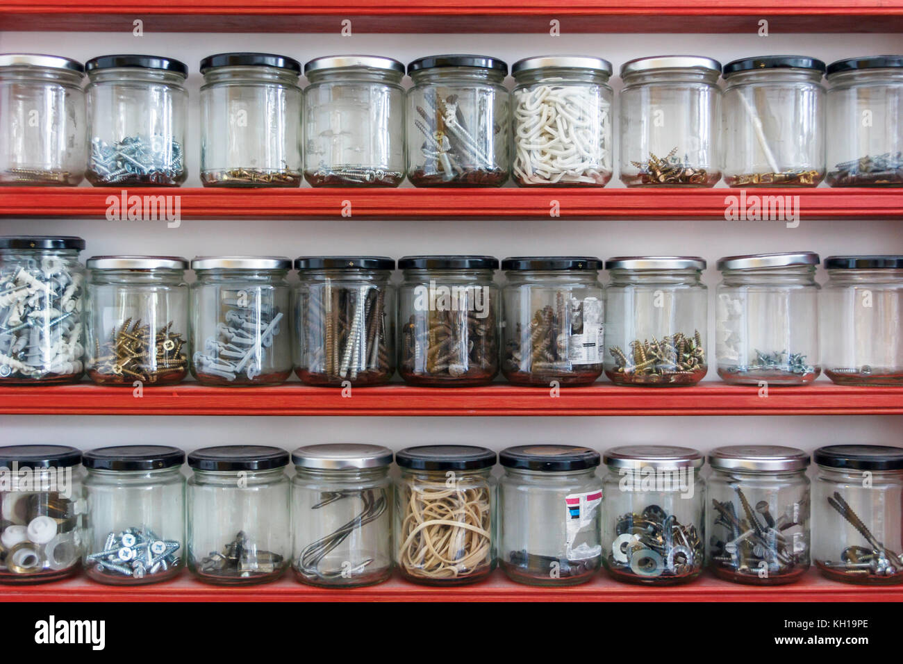 Sonstige Hardware Komponenten in Glas Marmelade Gläser gespeichert werden, die auf drei Regalen in einer eigenen Werkstatt Stockfoto