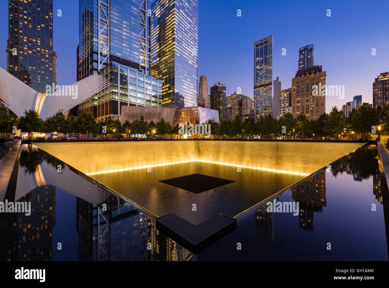 Im Norden einen reflektierenden Pool bei Dämmerung mit Blick auf das World Trade Center Tower 3 und 4 und die Oculus beleuchtet. Lower Manhattan, New York City Stockfoto