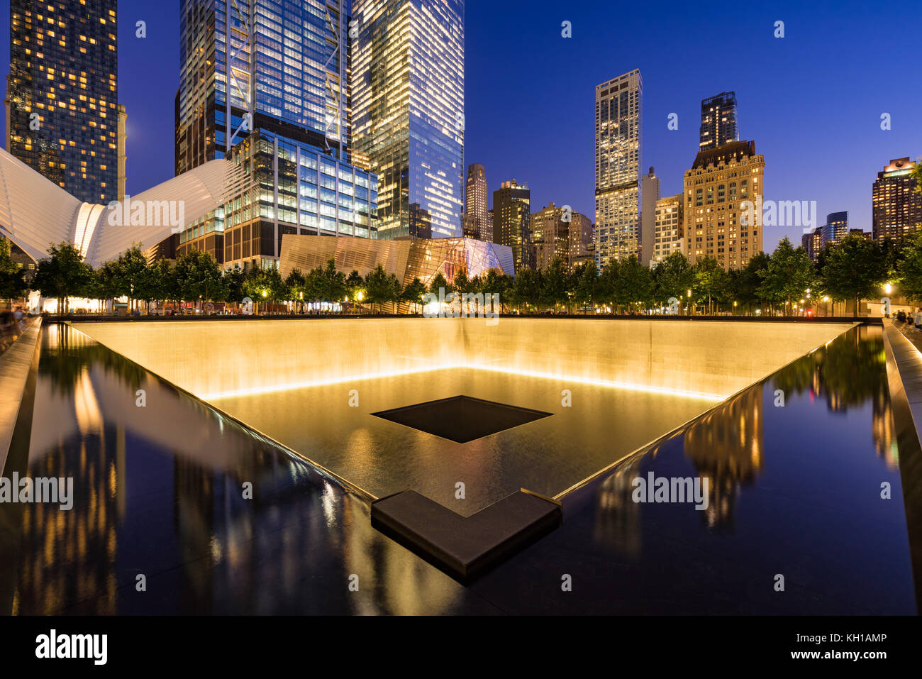 Im Norden einen reflektierenden Pool bei Dämmerung mit Blick auf das World Trade Center Tower 3 und 4 und die Oculus beleuchtet. Lower Manhattan, New York City Stockfoto