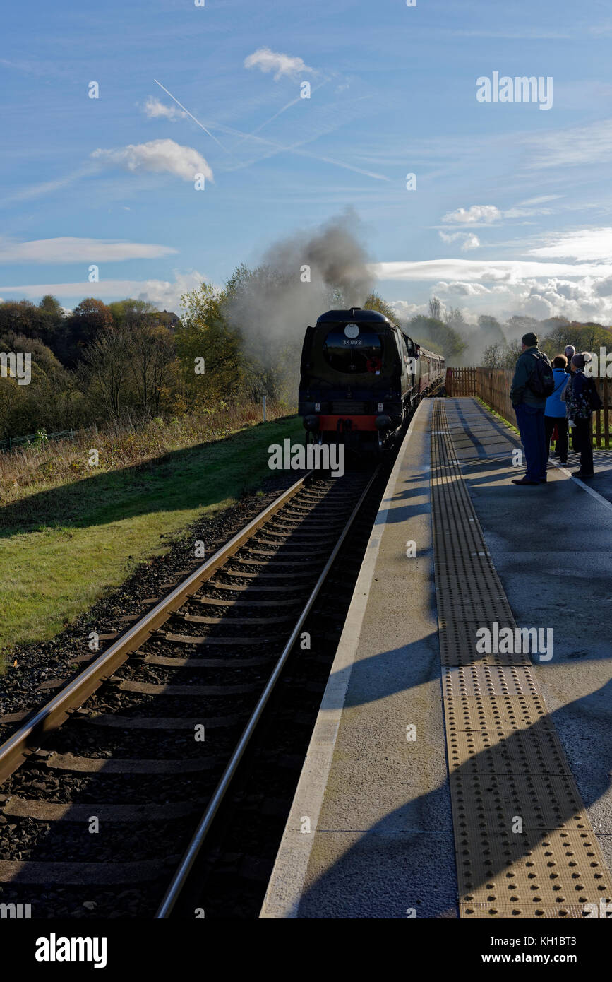 Dampfzug an Plattform ankommen, Passagiere warten hinter haptische Oberfläche, lange Schatten, um Grate Country Park Bahnhof Lancashire England bury Stockfoto