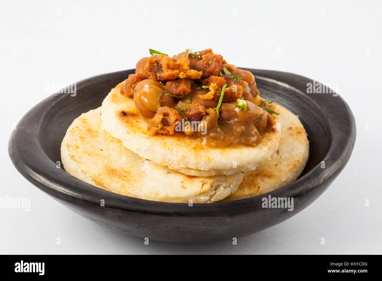 Die traditionelle kolumbianische Arepa gekrönt mit Bohnen und Schwarte Stockfoto