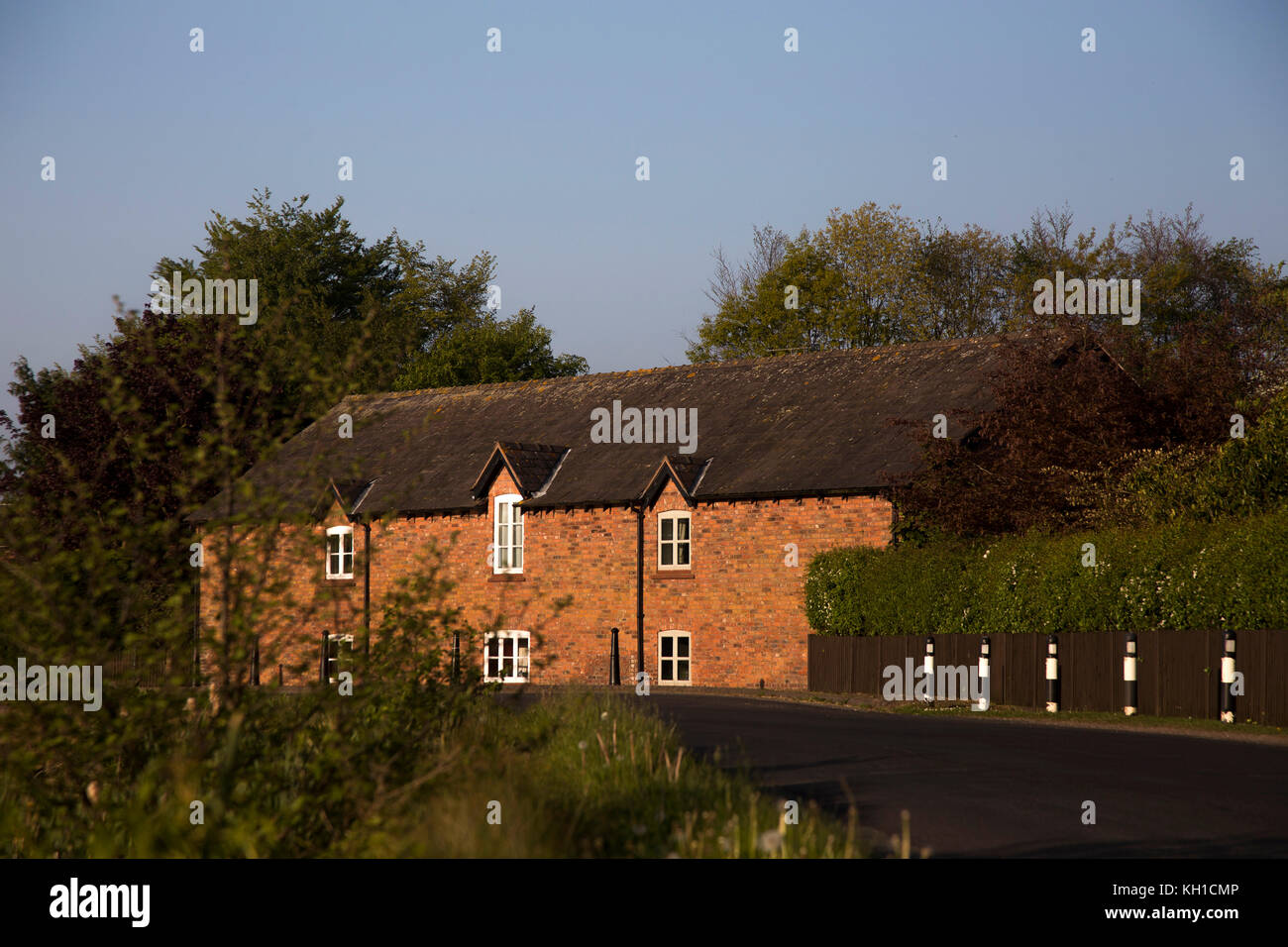 Häuser und Gebäude in der Nähe der Mühle Teich in der Nähe von Tarporley, Cheshire in frühen Abend Frühling Sonne Licht Stockfoto