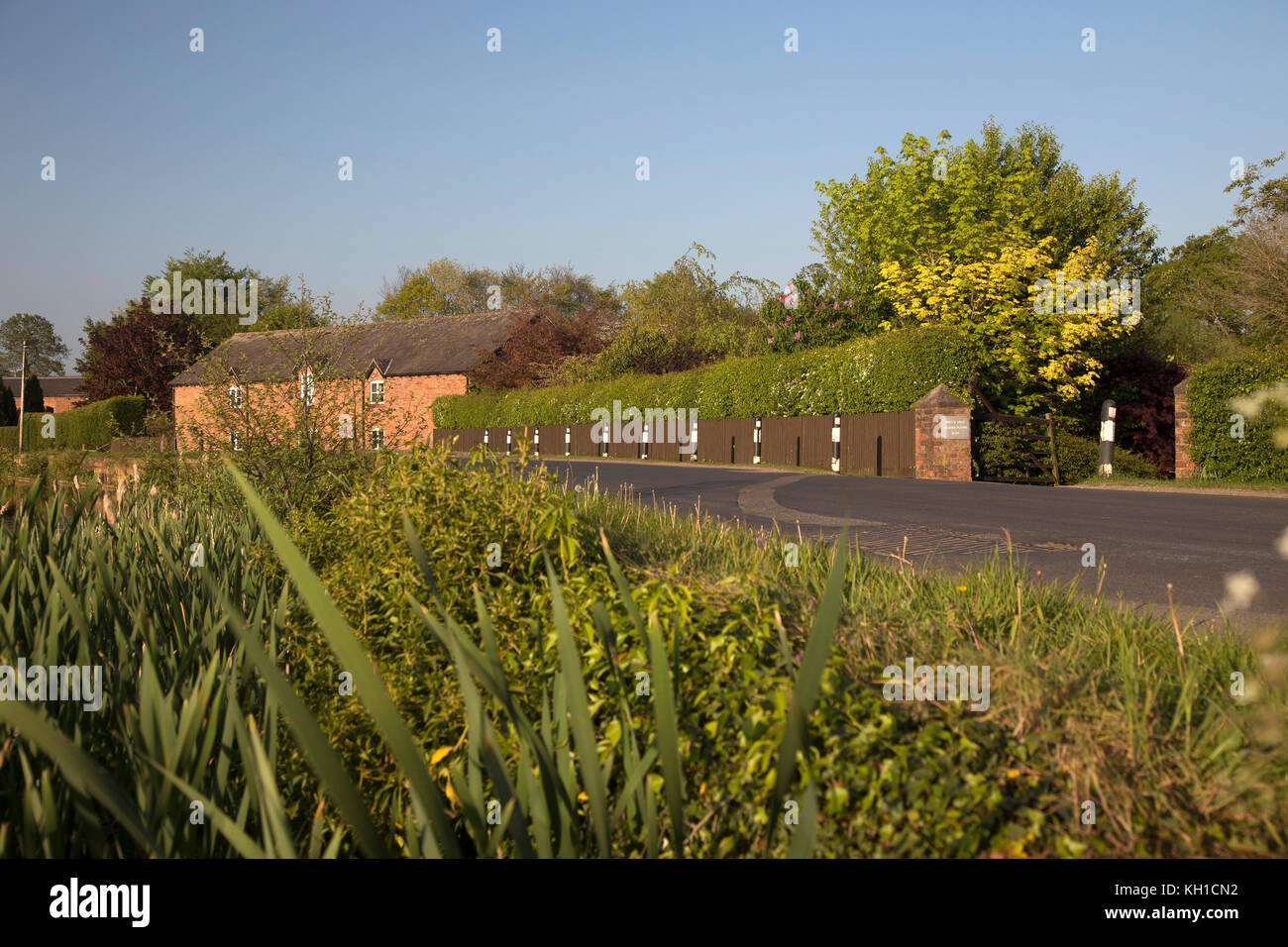 Häuser und Gebäude in der Nähe der Mühle Teich in der Nähe von Tarporley, Cheshire in frühen Abend Frühling Sonne Licht Stockfoto