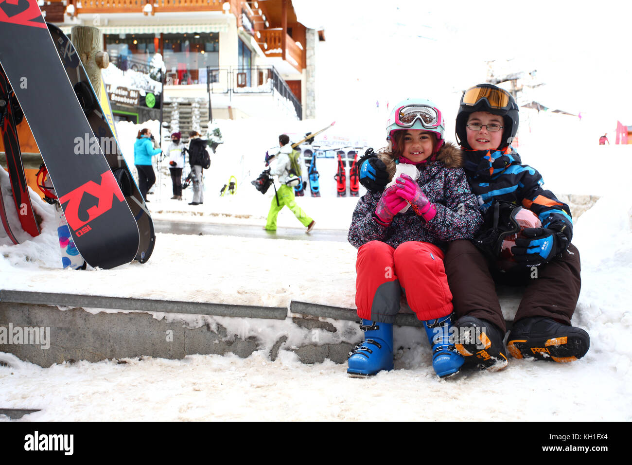 Kinder im Schnee tragen Skianzuege, Helme und Schutzbrillen Stockfoto