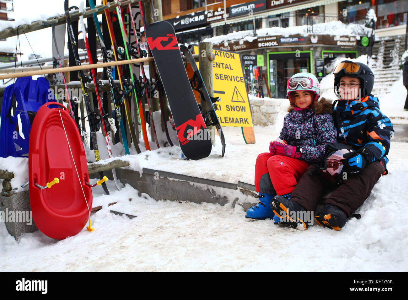 Kinder im Schnee tragen Skianzuege, Helme und Schutzbrillen Stockfoto