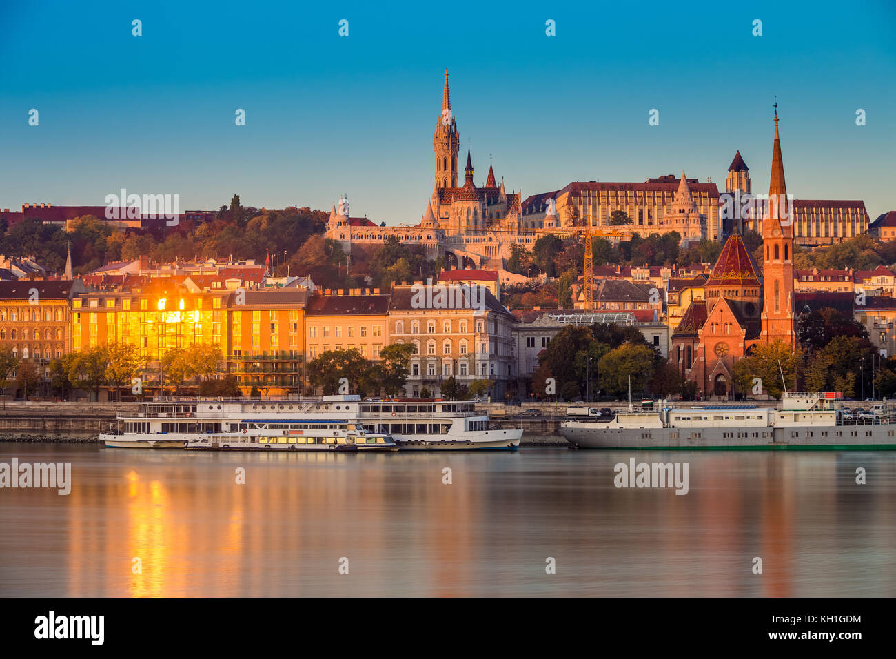 Budapest, Ungarn - Goldene Stunde am Morgen auf Buda-Seite mit der Buda-Burg, der St.-Matthias Kirche und der Fischerbastion mit alten Schiffen auf Ri Stockfoto