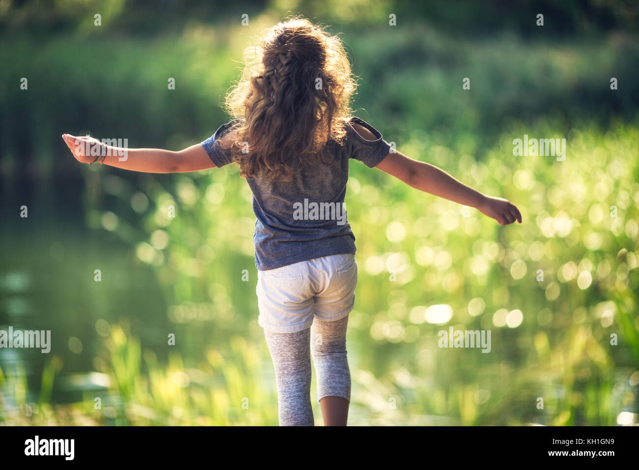 Gerne kleine Mädchen genießen die Natur und den sonnigen Tag im Park Stockfoto