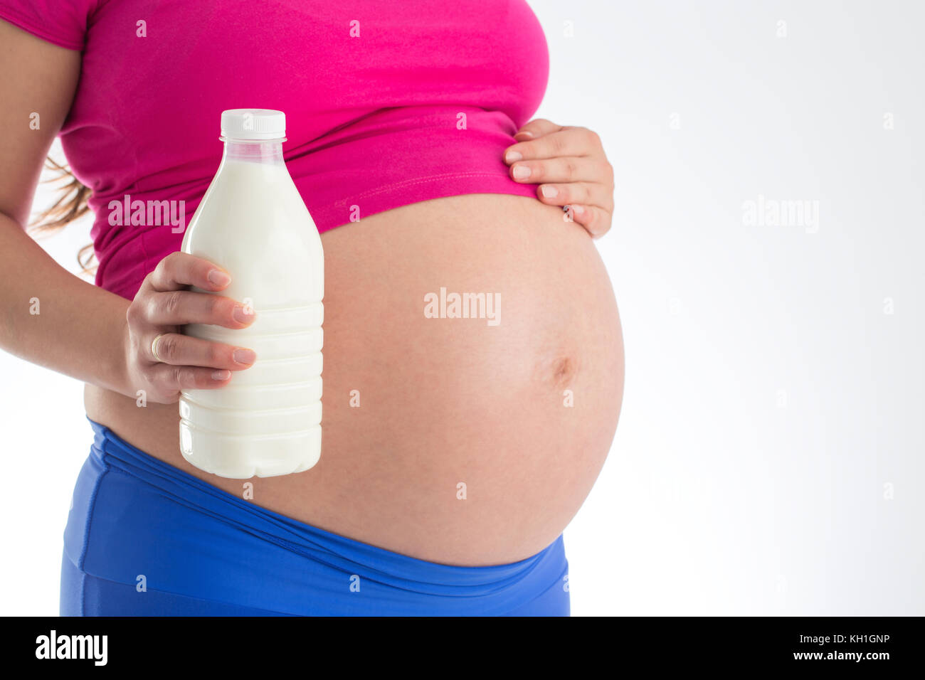 Schwangerschaft und gesundes Menü - schwangere Frau mit Milch Flasche auf weißem Hintergrund Stockfoto