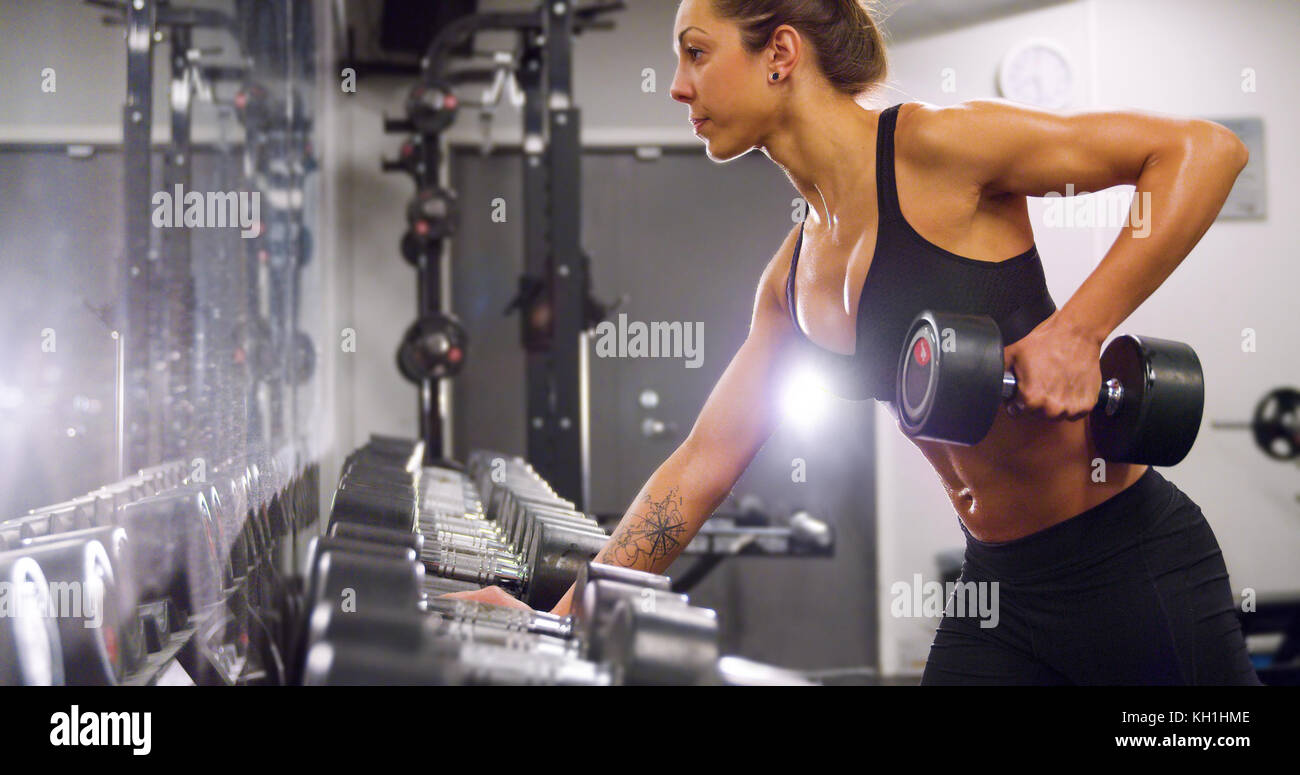 Engagierte Frau, die Ausbildung und das Anheben der Gewichte in Fitness Gym Stockfoto