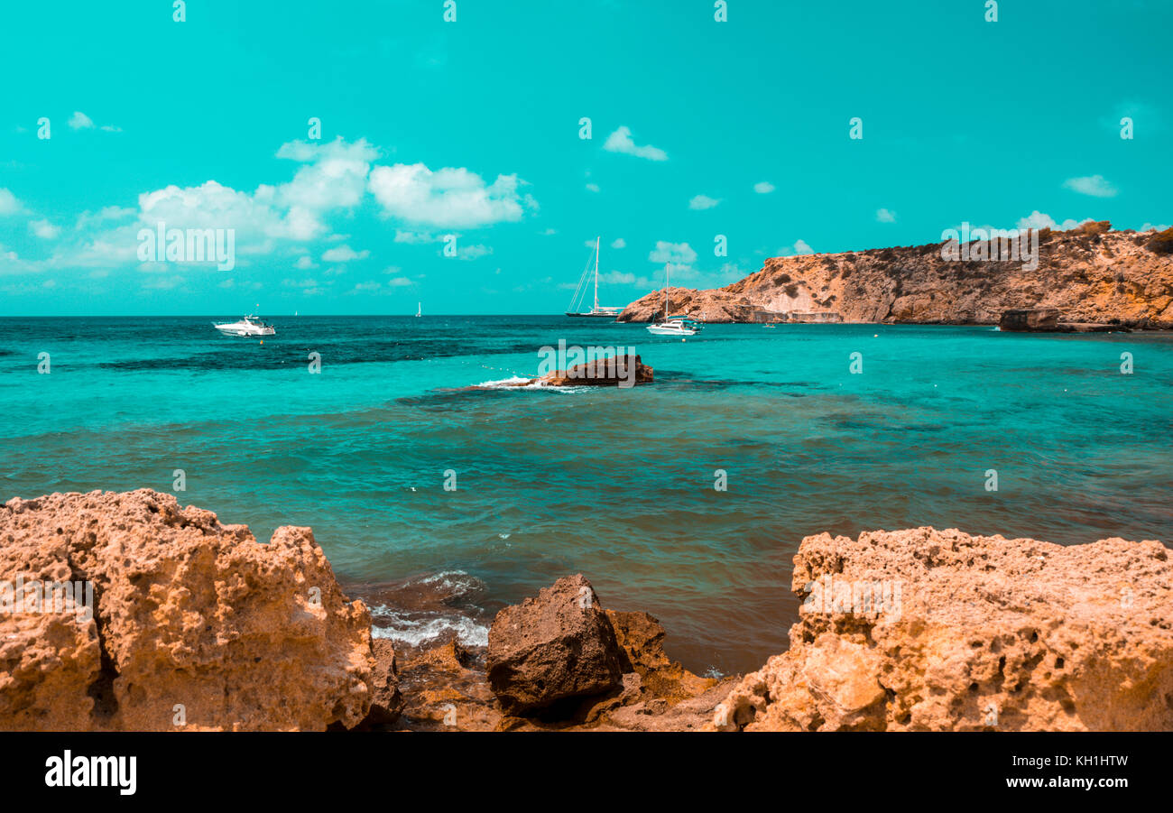 Blaugrün und Orange Stimmung von Cala Tarida Beach und schönen mediterranen Küste der Insel Ibiza, Teil der Balearischen Inseln in Spanien. Stockfoto