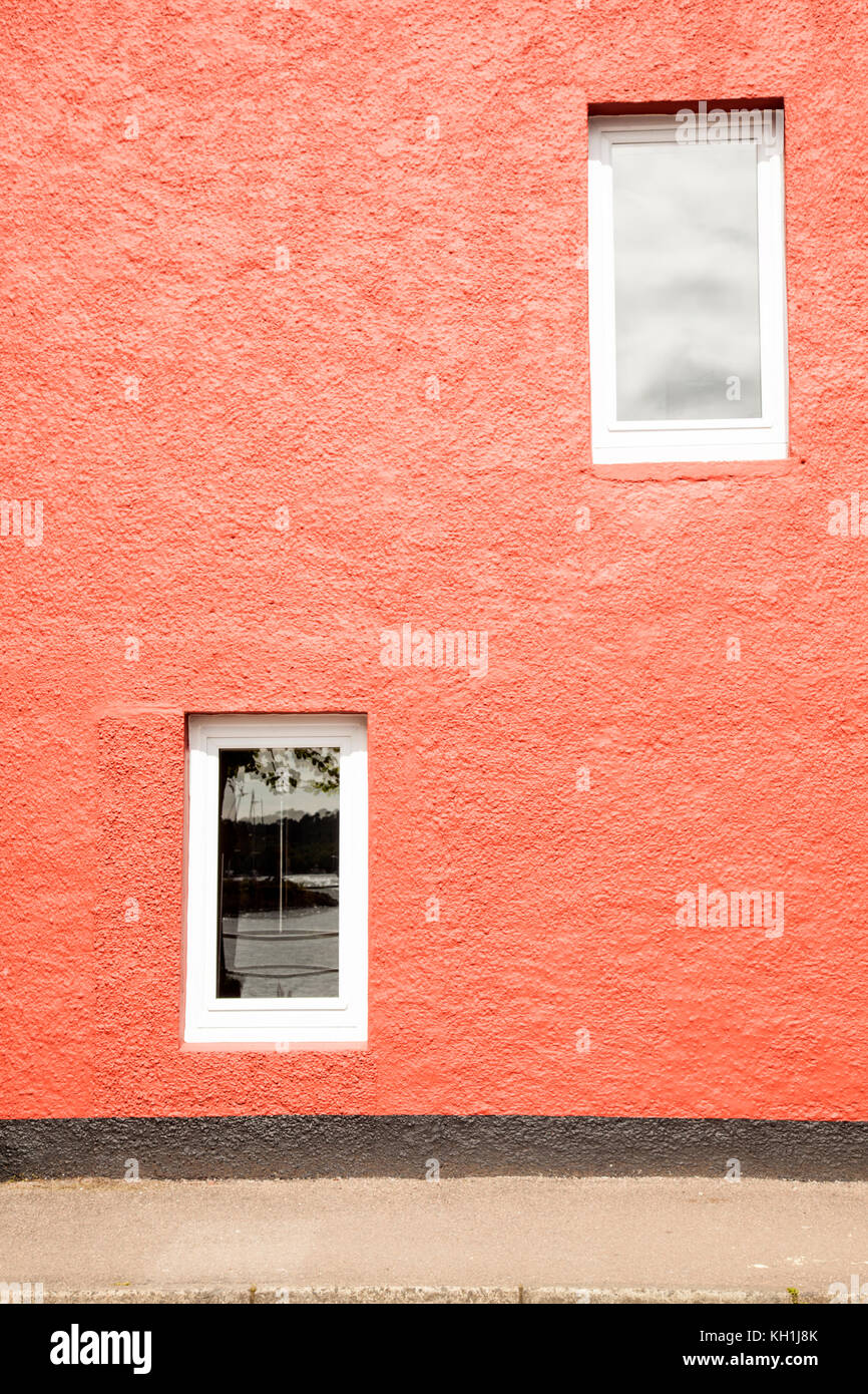 Orange gestrichenes Gebäude mit zwei Fenstern zu verschiedenen, mit Gestell aus Holz, weiß lackiert Stockfoto