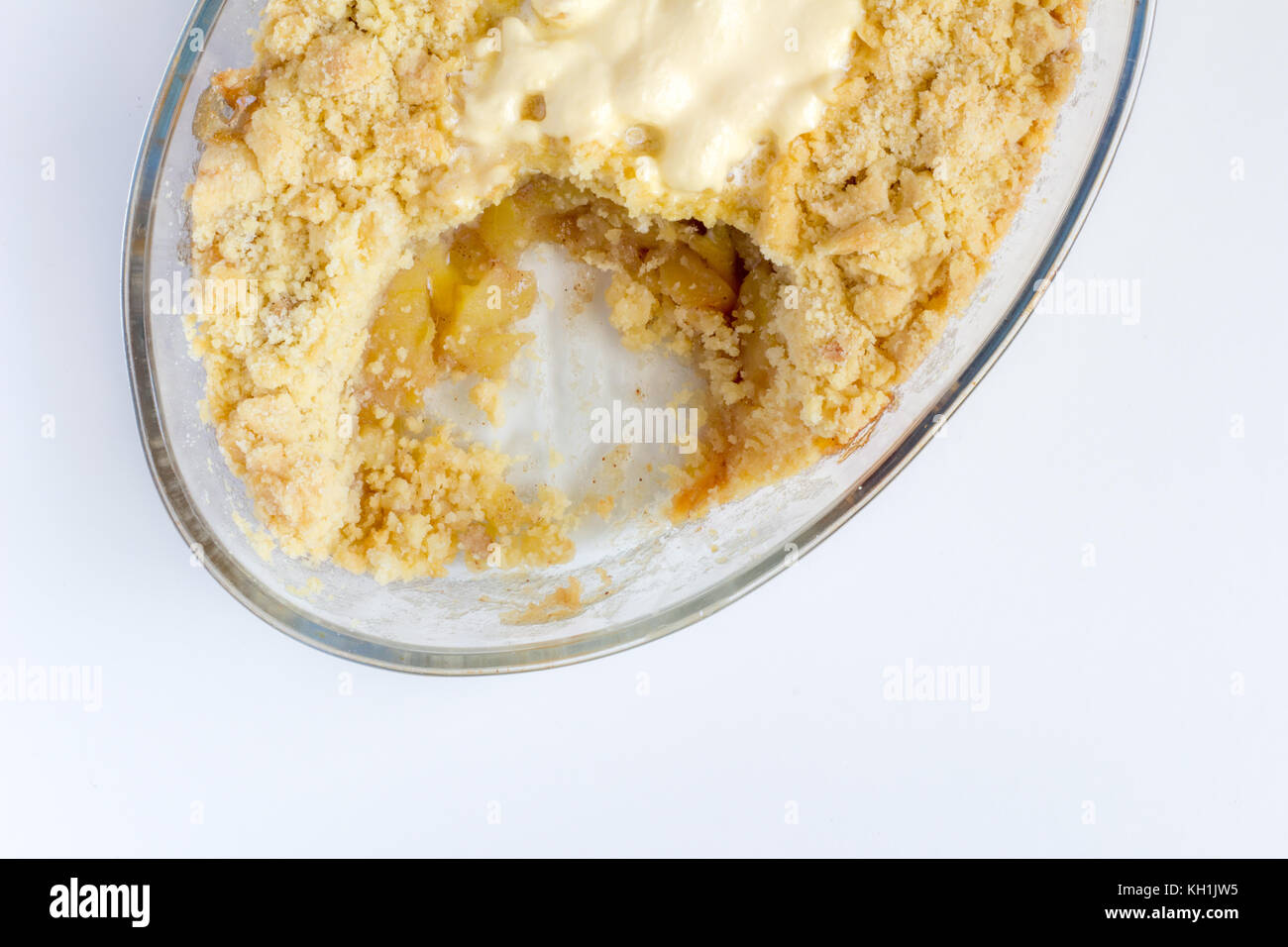 Gekochte Cinnamon Apple Pie bröckeln im Glas ovale Schale auf weißem Hintergrund - Ansicht von oben Stockfoto