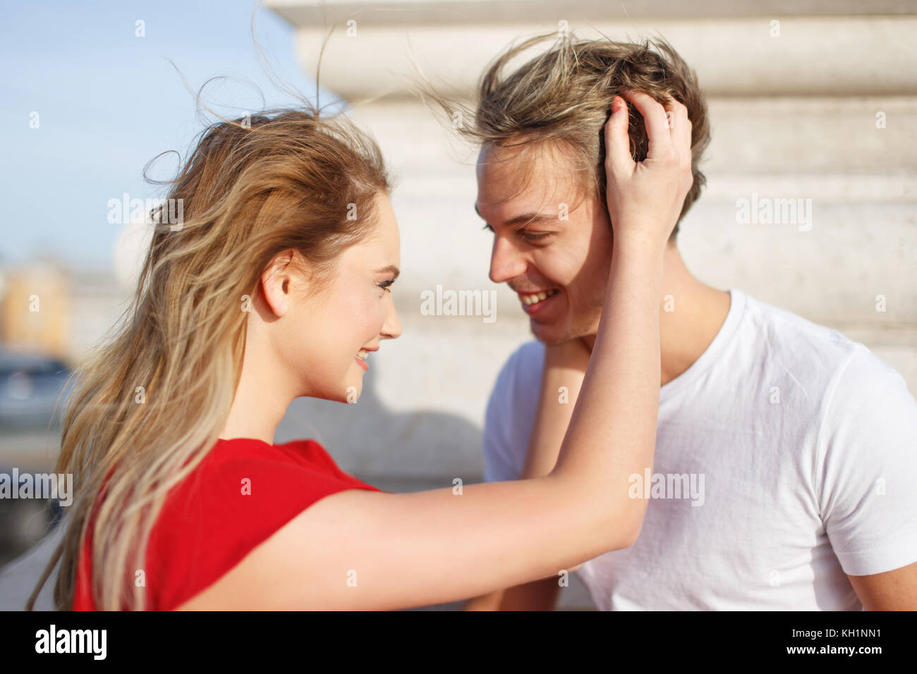 Glückliches Paar am ersten Tag am Frühling, junge blonde Frau umarmen Freund im Freien Stockfoto