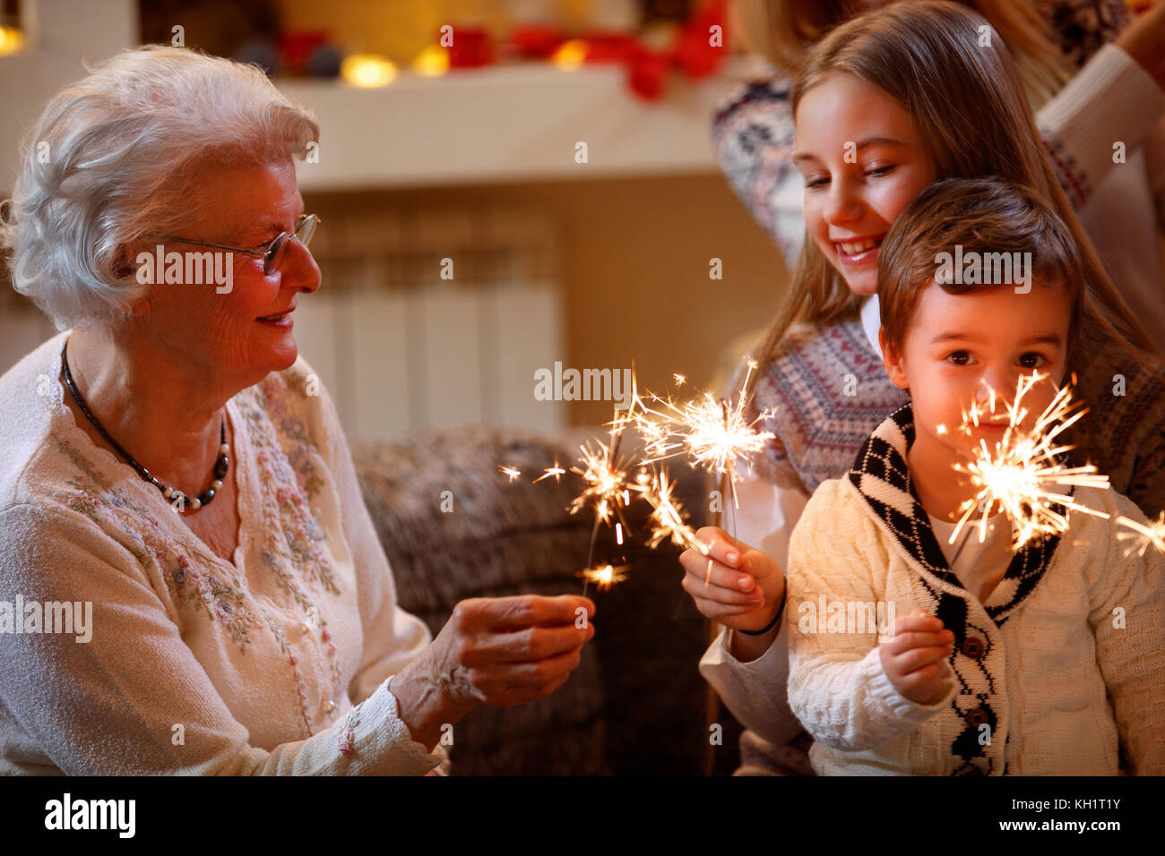 Lächelnd Enkel und Großeltern mit Sprinklern Weihnachten feiern. Stockfoto