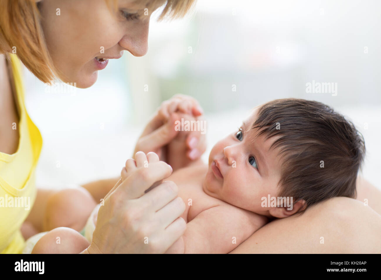Seitenansicht der schönen Mutter und ihrem Säugling Baby an einander, Zeit, gemeinsam zu Hause Stockfoto