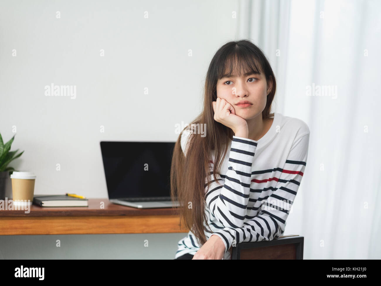 Asien Frau über das Arbeiten bei Cafe Restaurant gelangweilt, weiblich rest Kinn auf der Hand mit Stress Gefühl mit Laptop und Kaffee Tasse auf dem Tisch im Coffee Shop, bori Stockfoto
