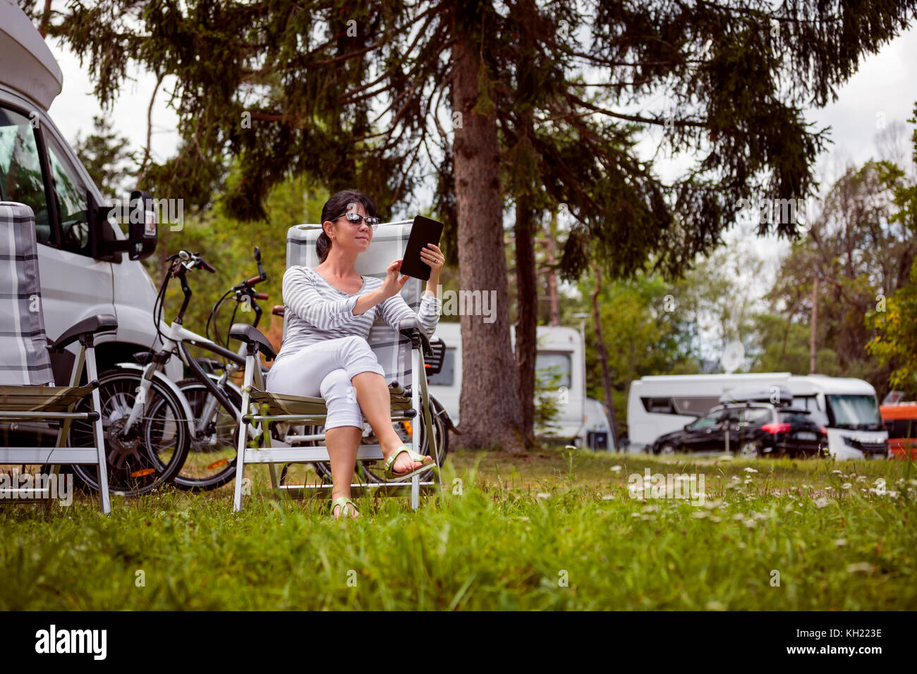 Frau an der Tafel in der Nähe des Camping suchen. caravan Auto Urlaub. Urlaub Reisen, Urlaub im Reisemobil rv. wi-fi Verbindung Informatio Stockfoto Frau an der Tafel in der Nähe des Camping suchen. caravan Auto Urlaub. Urlaub Reisen, Urlaub im Reisemobil rv. wi-fi Verbindung Informatio Stockfoto